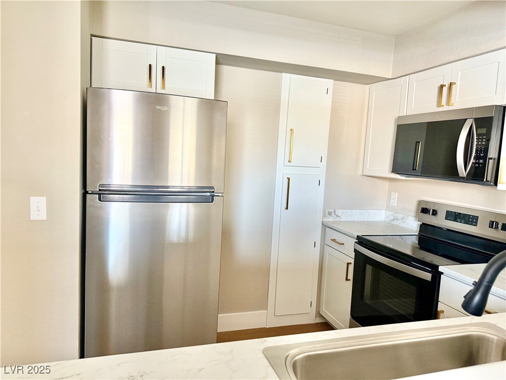 1150 North Buffalo Drive, Unit 2025 Las Vegas, NV 89128 - Photo 17 of 20 Kitchen with appliances with stainless steel finishes and white cabinets