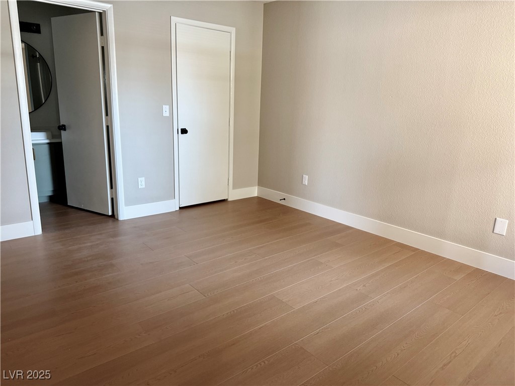 1150 North Buffalo Drive, Unit 2025 Las Vegas, NV 89128 - Photo 4 of 20 Unfurnished bedroom featuring wood finished floors and baseboards