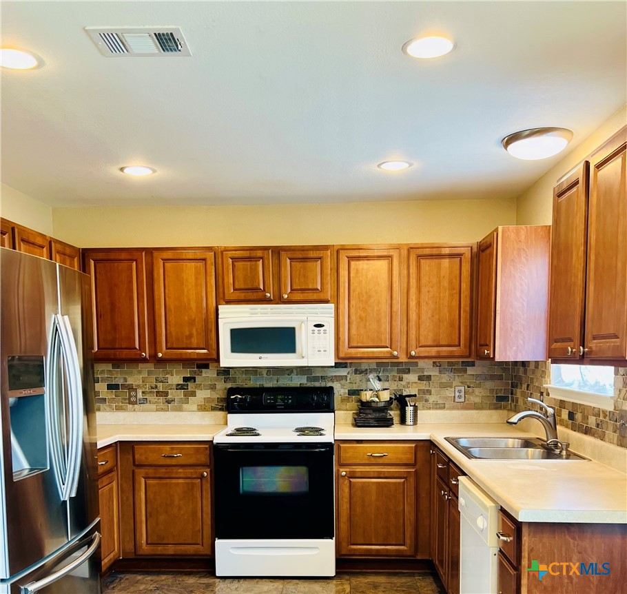 8210 Sunset Trail Temple, TX 76502 - Photo 4 of 15 a kitchen with stainless steel appliances granite countertop a stove a sink dishwasher and a microwave oven with cabinets
