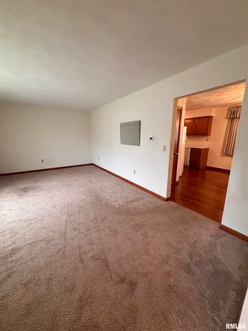 an empty room with wooden floor and a ceiling fan