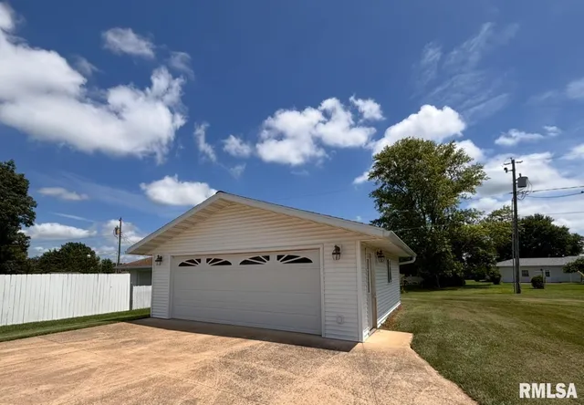 a view of a house with a yard and a garage