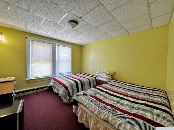 a bedroom with two beds and a window