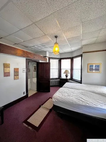 a bed room with a bed mirror and a window