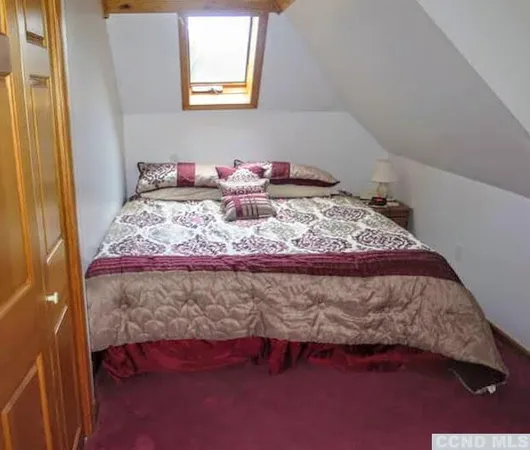 a bed sitting in a bedroom next to a window