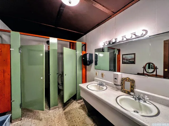 a bathroom with a double vanity sink and a mirror