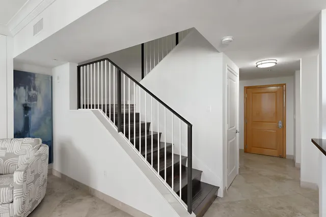 a view of a hallway with windows and stairs