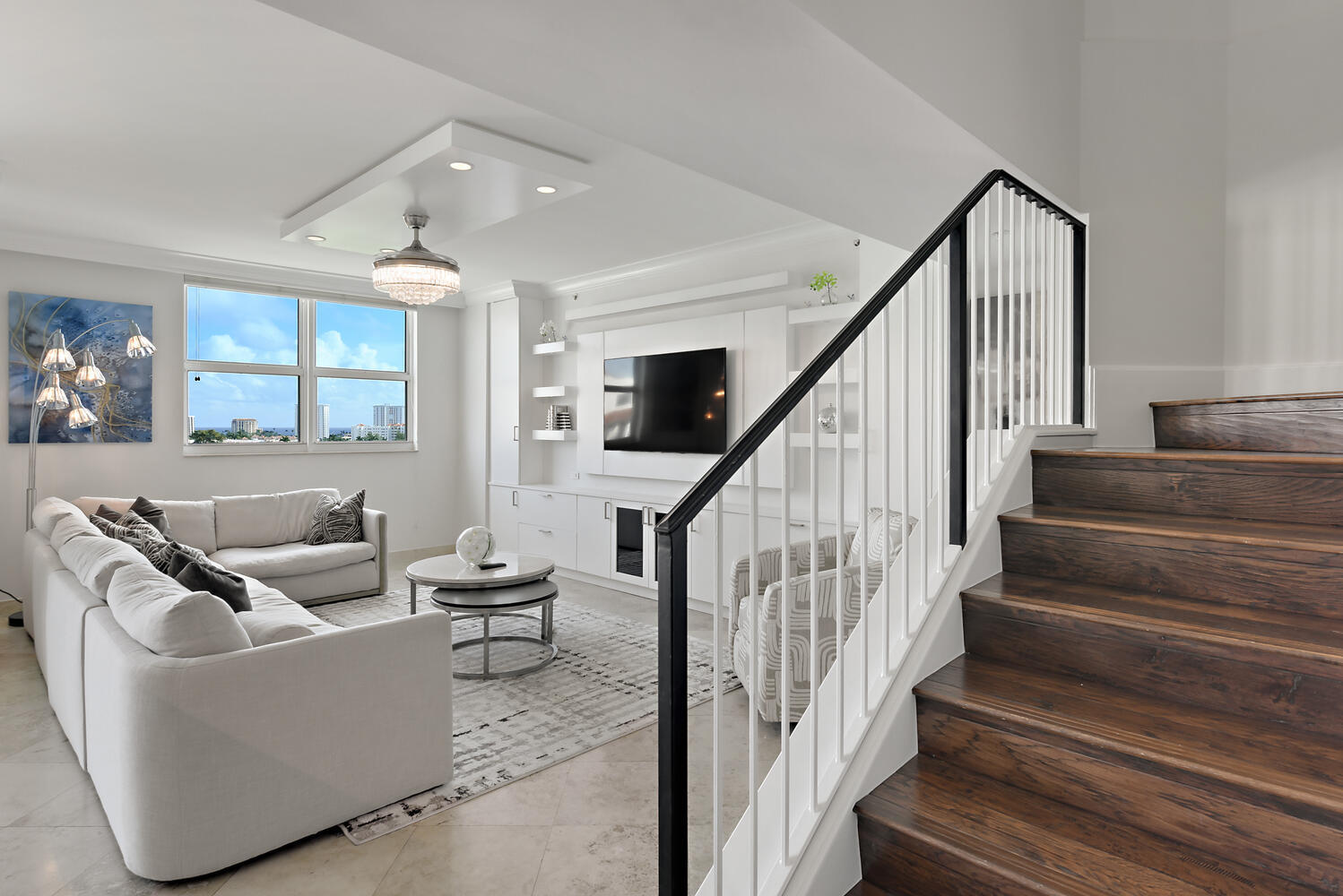 99 Southeast Mizner Boulevard, Unit PH 909 Boca Raton, FL 33432 - Photo 13 of 51 a living room with couches and stairs with wooden floor