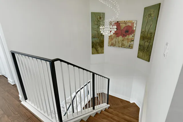 a view of a hallway with wooden floor and stairs