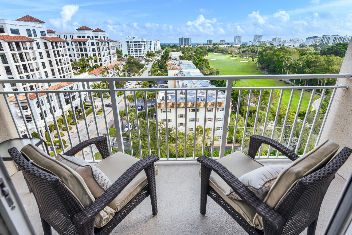 99 Southeast Mizner Boulevard, Unit PH 909 Boca Raton, FL 33432 - Photo 3 of 51 a view of a balcony with two chairs and a potted plant