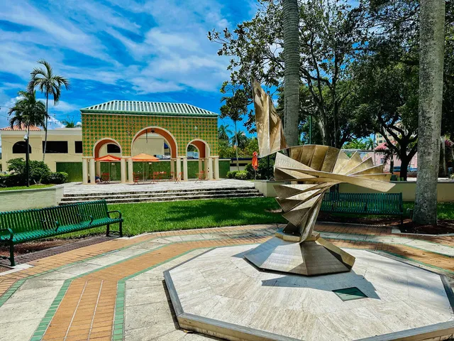 a view of a park along palm trees and sign board