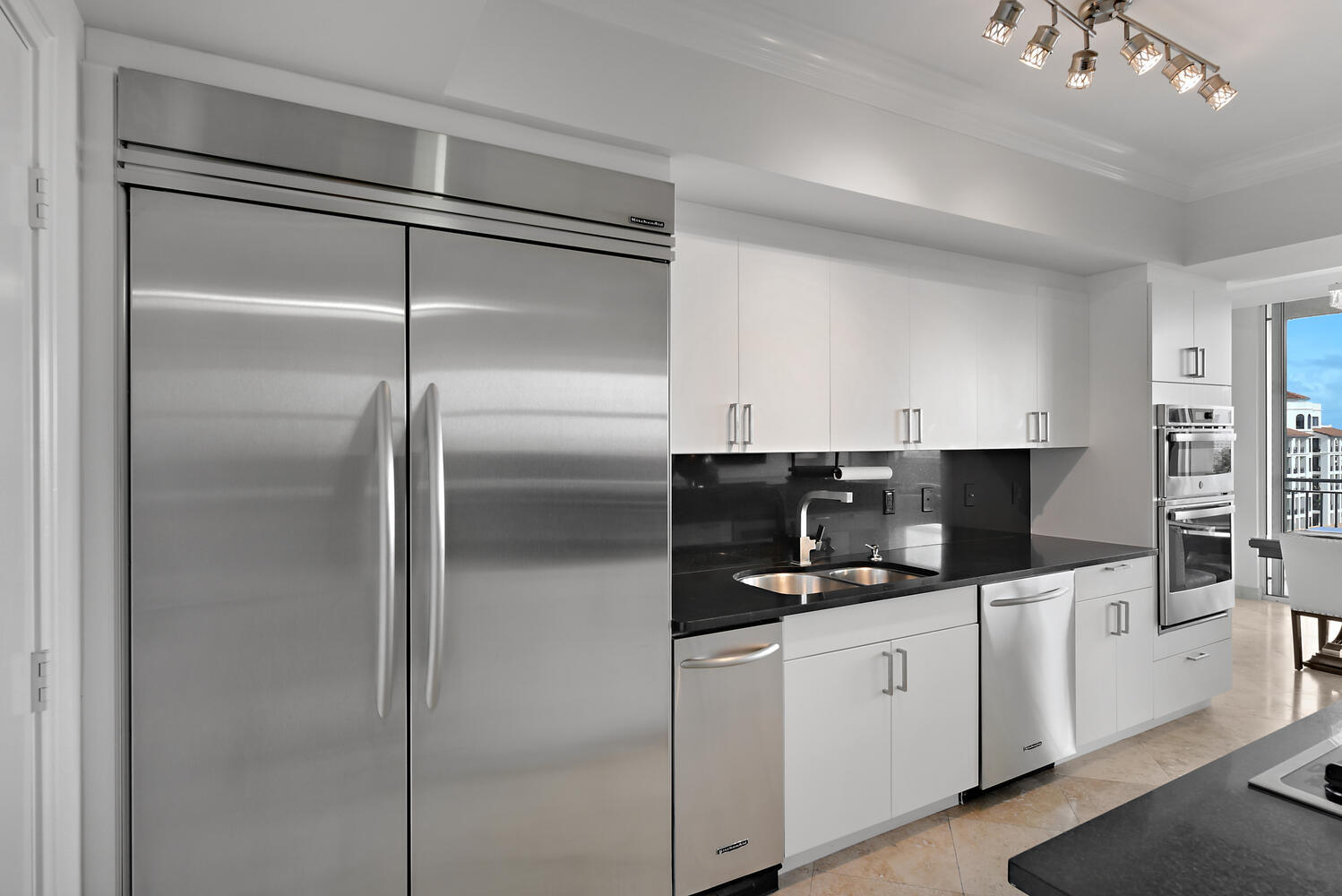 99 Southeast Mizner Boulevard, Unit PH 909 Boca Raton, FL 33432 - Photo 9 of 51 a kitchen with a refrigerator and white cabinets
