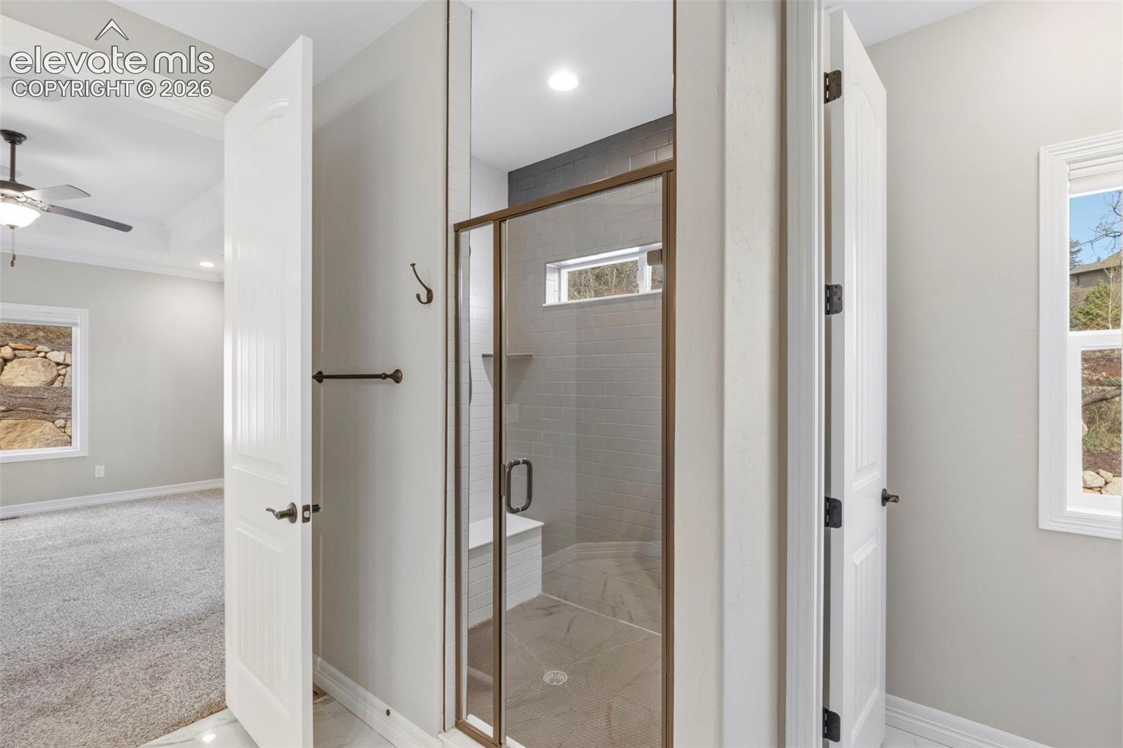 5375 Old Star Ranch View Colorado Springs, CO 80906 - Photo 27 of 47 Walk-in shower with a glass enclosure, built-in bench, and tiled walls