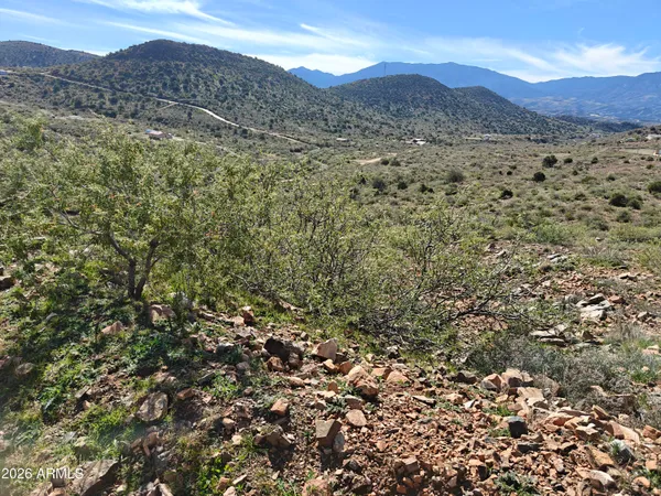 a view of a mountain range with lush green hillside