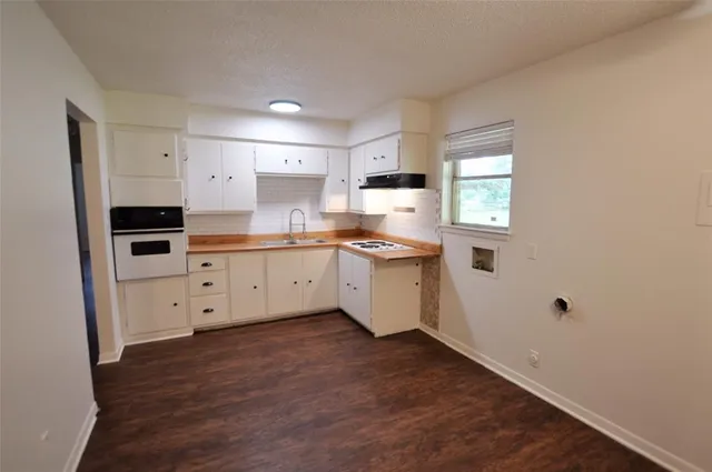a kitchen with white cabinets appliances and sink