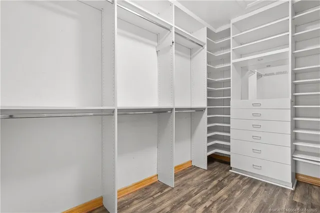 a view of walk in closet with empty racks