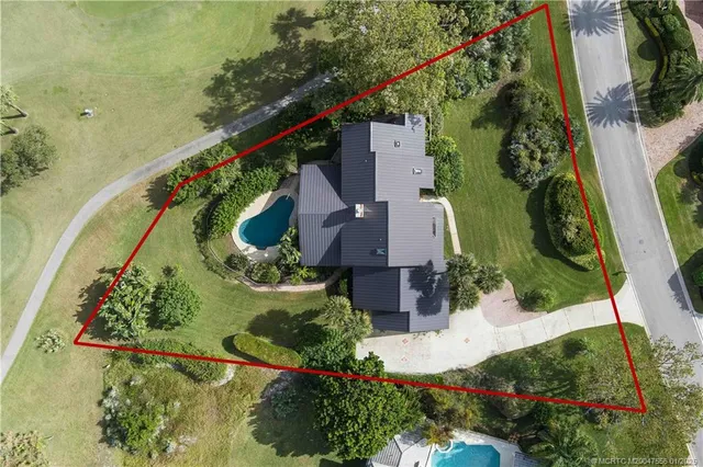 an aerial view of residential houses with outdoor space and swimming pool