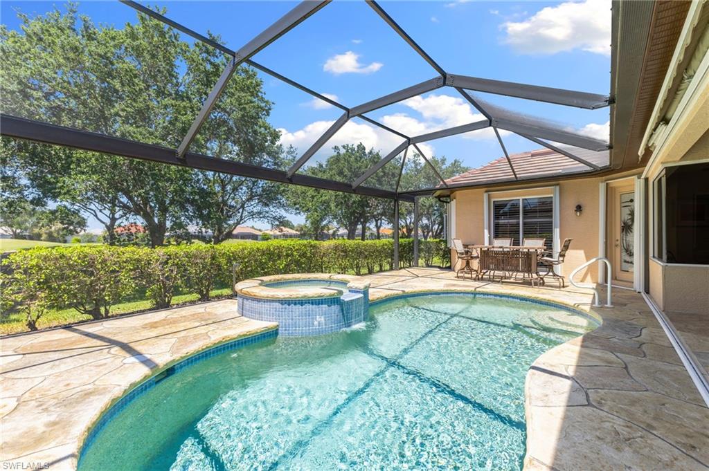 8886 Lely Island Circle Naples, FL 34113 - Photo 11 of 44 a view of a swimming pool with a patio