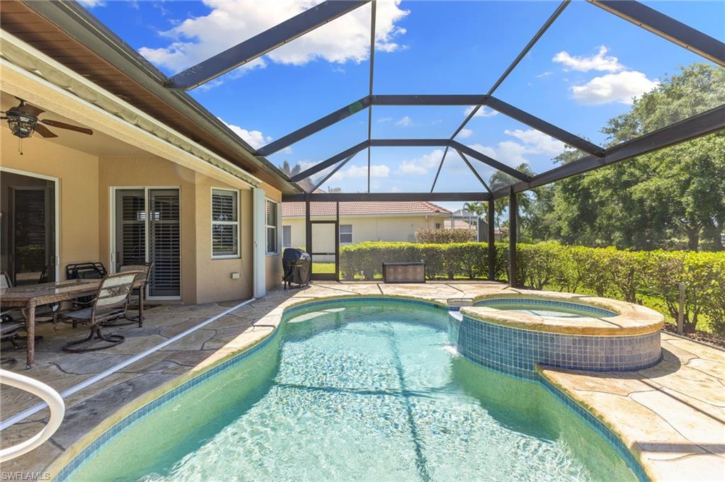 8886 Lely Island Circle Naples, FL 34113 - Photo 16 of 44 a view of a swimming pool with a patio