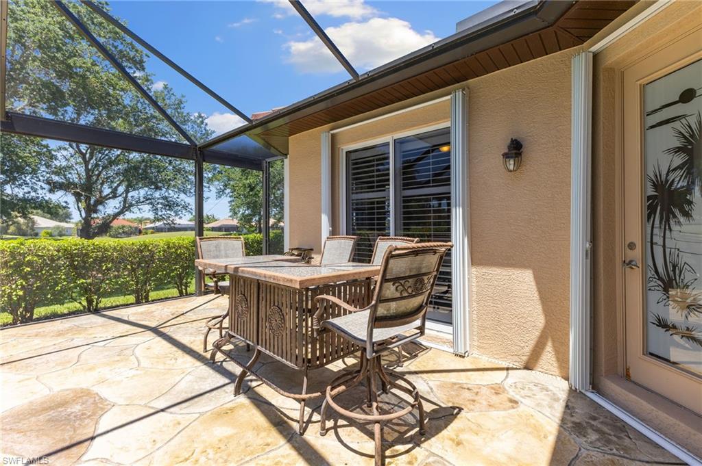 8886 Lely Island Circle Naples, FL 34113 - Photo 18 of 44 a view of a patio with table and chairs and potted plants
