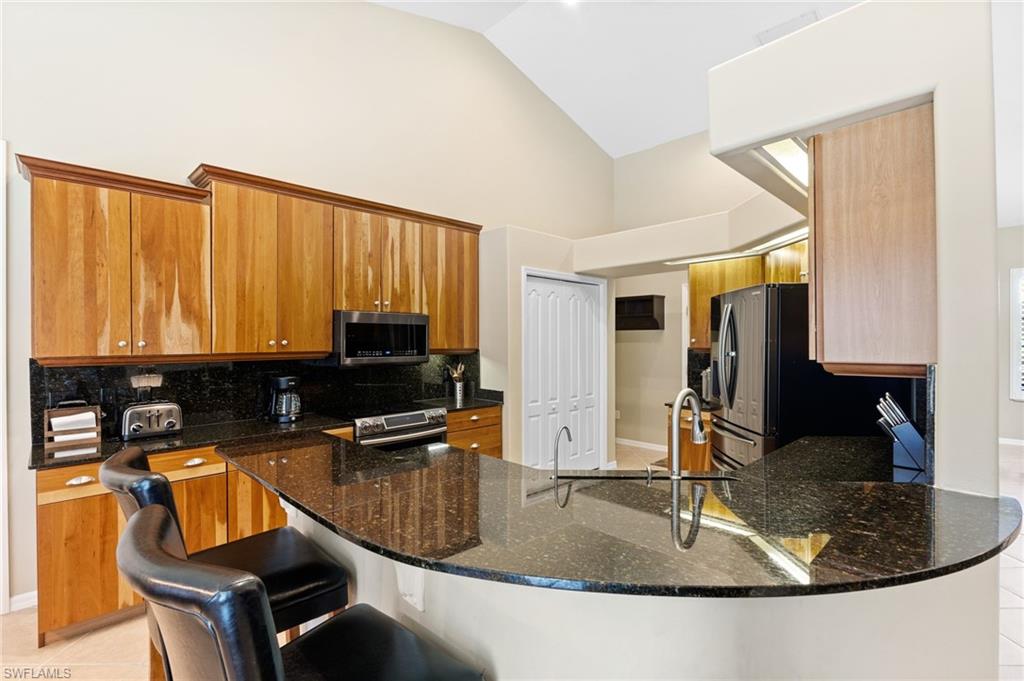 8886 Lely Island Circle Naples, FL 34113 - Photo 25 of 44 a kitchen with a sink a counter top space and cabinets