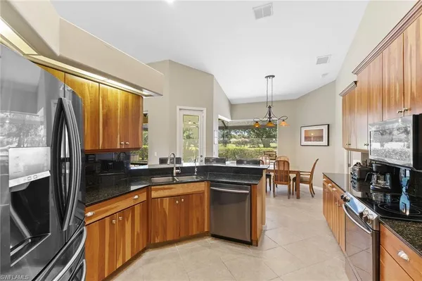 a large kitchen with stainless steel appliances a stove sink and cabinets