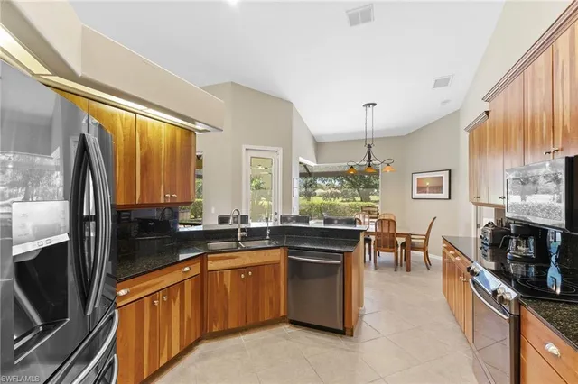 a large kitchen with stainless steel appliances a stove sink and cabinets
