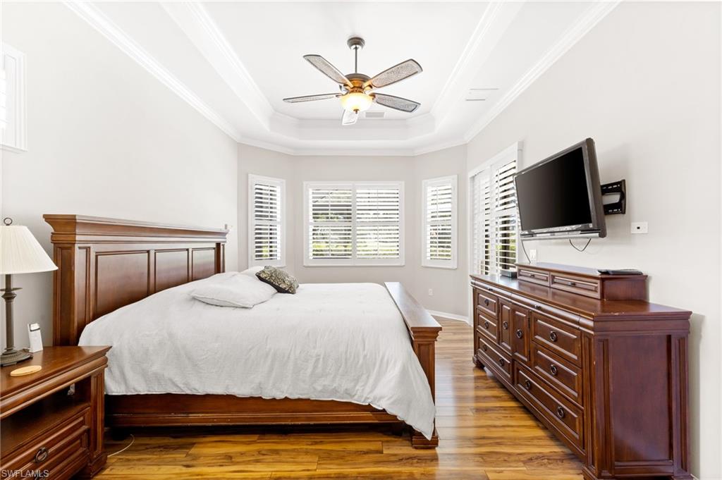 8886 Lely Island Circle Naples, FL 34113 - Photo 27 of 44 a bedroom with a bed and a flat screen tv