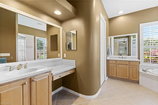 a bathroom with a granite countertop sink a mirror and a bathtub