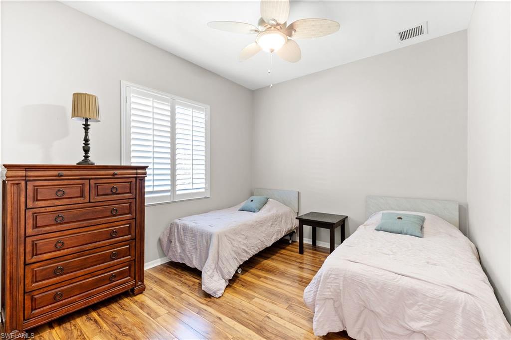 8886 Lely Island Circle Naples, FL 34113 - Photo 35 of 44 a bedroom with two beds and a chandelier