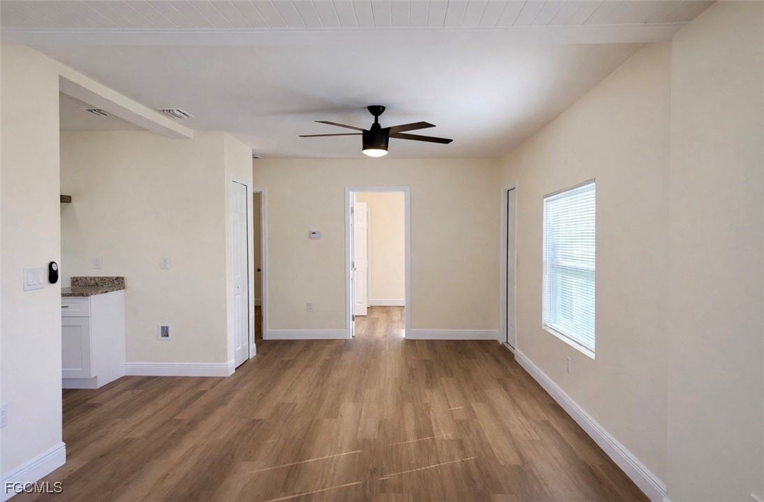261 Miramar Road Fort Myers, FL 33905 - Photo 11 of 24 an empty room with wooden floor ceiling fan and windows