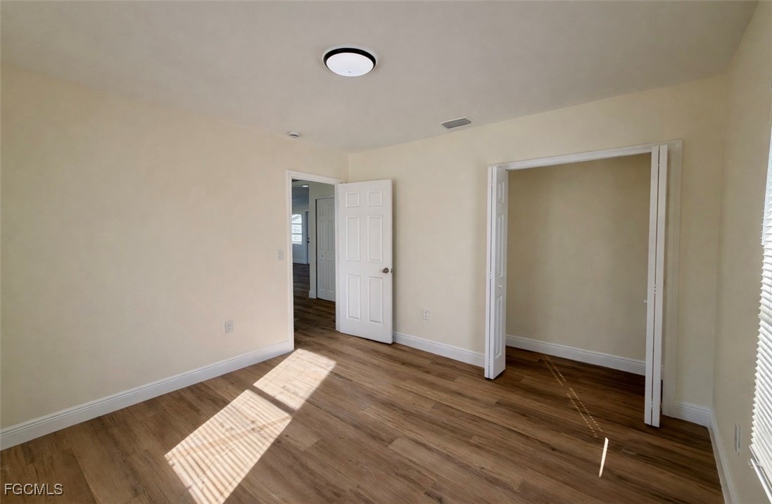 261 Miramar Road Fort Myers, FL 33905 - Photo 13 of 24 an empty room with wooden floor and windows
