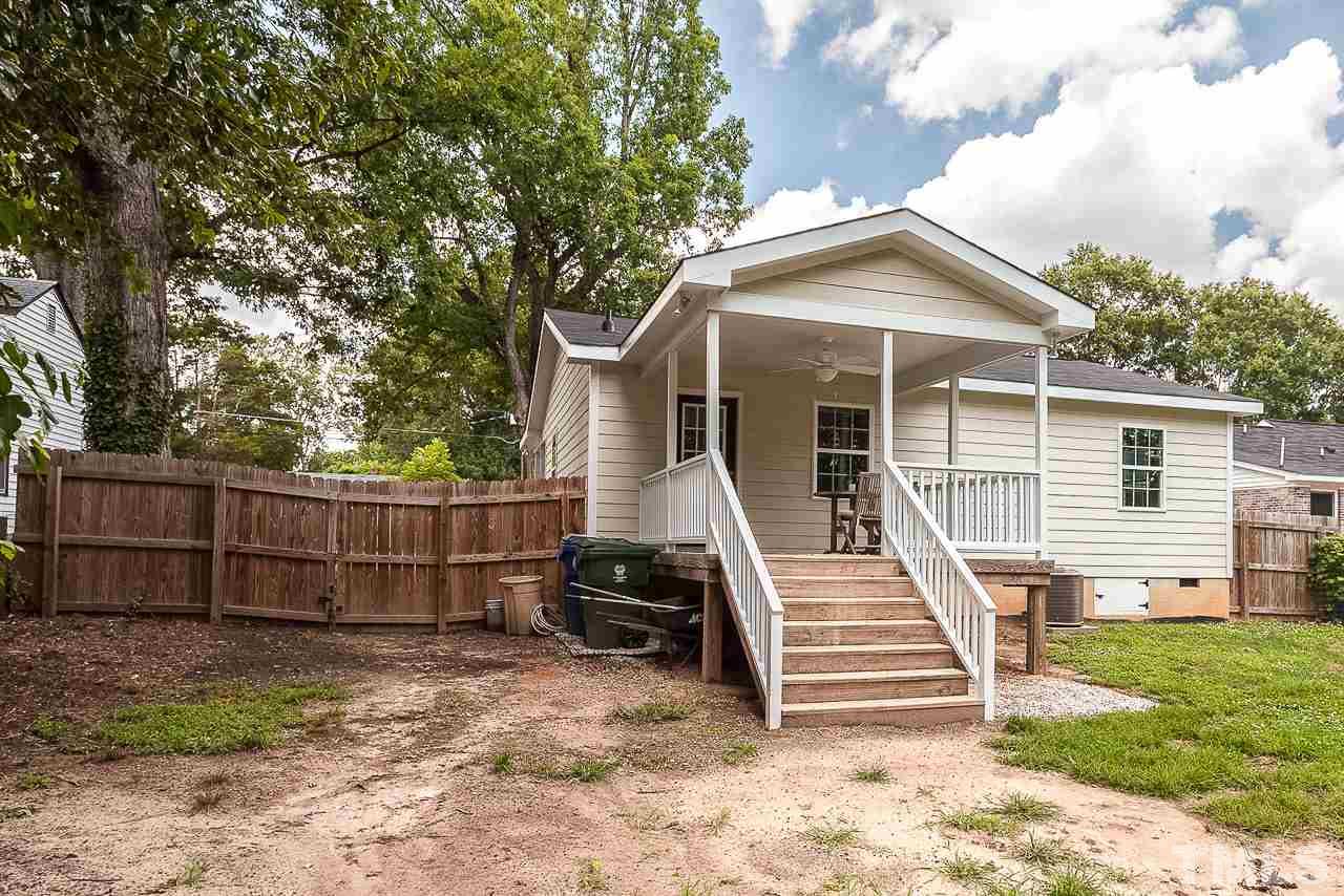 620 Brighton Road Raleigh, NC 27610 - Photo 5 of 25 a view of a small house in front of a yard with wooden fence and a bench