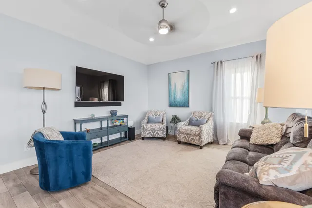 a view of a living room kitchen with wooden floor and furniture