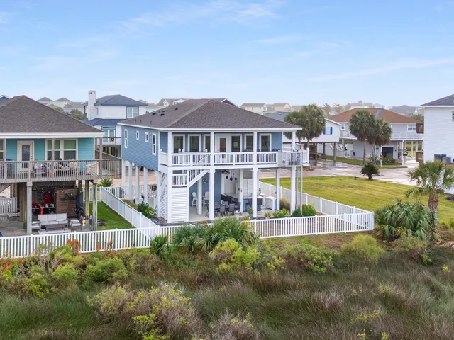 an aerial view of residential houses with outdoor space and ocean view