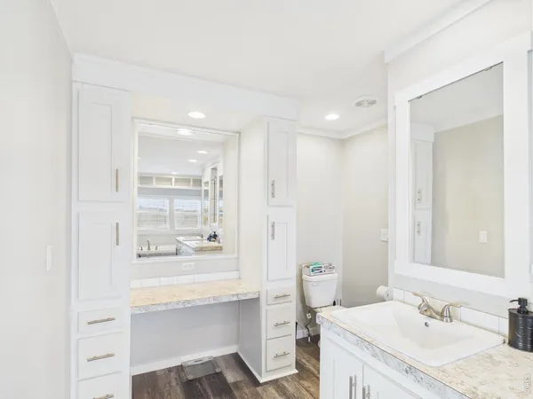 a bathroom with a sink double vanity granite tub shower and a mirror