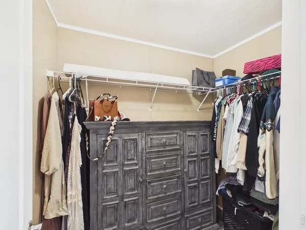a view of walk in closet with clothes and shoes