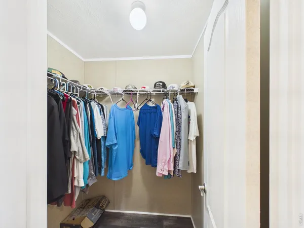 a view of walk in closet with clothes