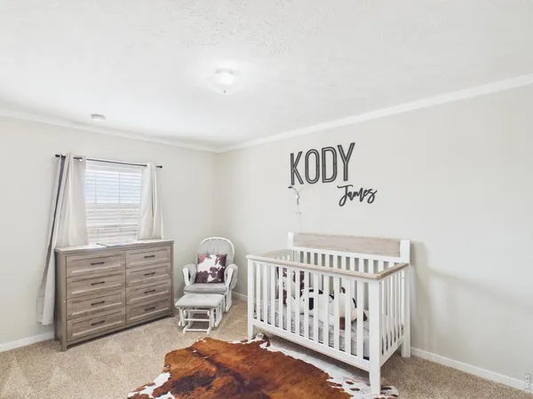 a bedroom with a baby bed a chandelier and closet