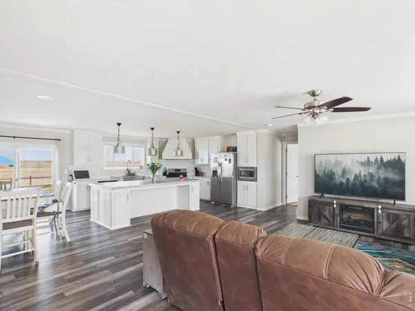 a living room with furniture a flat screen tv and kitchen view