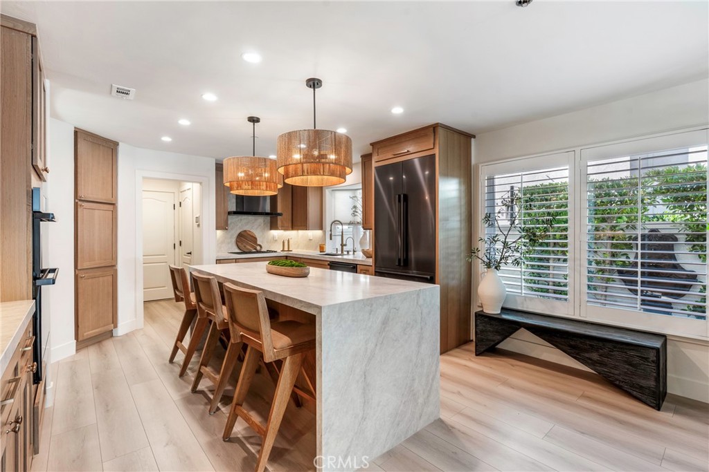 20 Regina Dana Point, CA 92629 - Photo 19 of 60 a open kitchen with stainless steel appliances granite countertop a refrigerator a sink dishwasher a stove and a dining table with wooden floor
