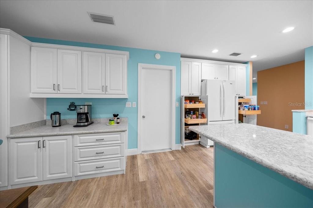 8720 Southwest 90th Street, Unit A Ocala, FL 34481 - Photo 16 of 71 a kitchen with granite countertop a refrigerator sink and white cabinets