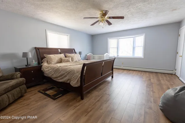a spacious bedroom with a bed a couch and a window