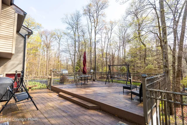 a view of a swimming pool with a patio and wooden flooring
