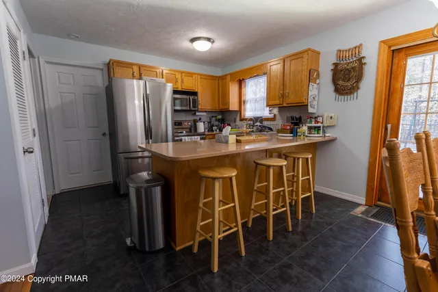 a kitchen with stainless steel appliances a table and chairs in it