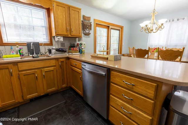 a kitchen with stainless steel appliances granite countertop a sink a stove and a wooden cabinets