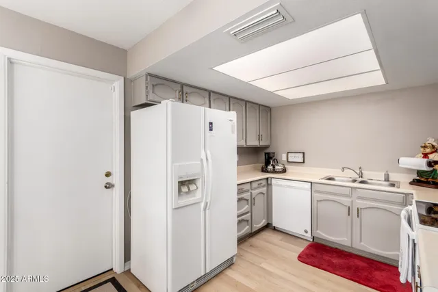 a kitchen with white cabinets and white appliances