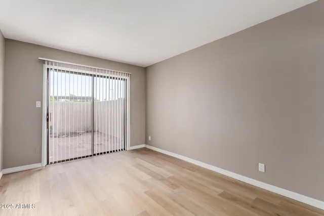 an empty room with wooden floor and sliding door