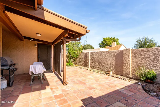 a patio with table and chairs and potted plants