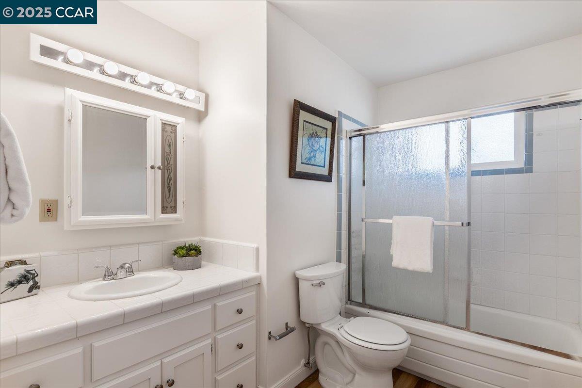 4081 Salem Street Concord, CA 94521 - Photo 19 of 27 a bathroom with a granite countertop sink a toilet and a mirror