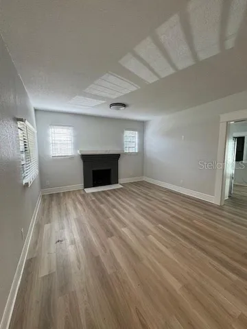 wooden floor fireplace and windows in an empty room